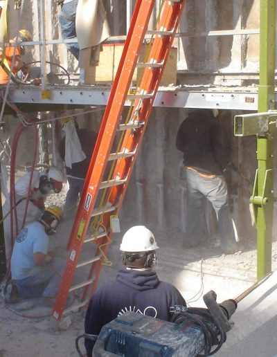 Hand chipping work being done at a demolition site.