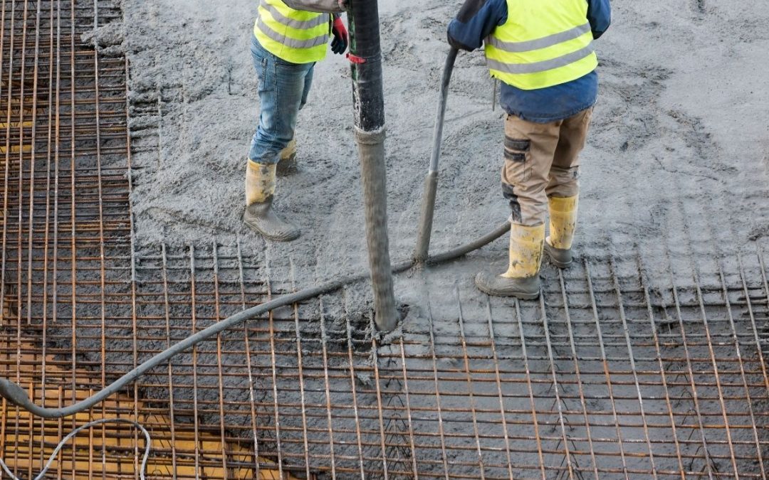 Construction workers pouring in concrete.