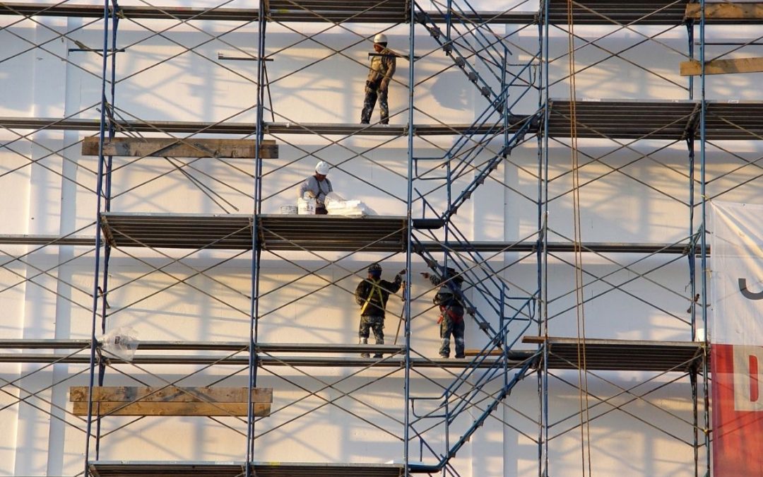 Construction workers scaffolding the system of the building