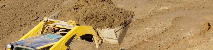 A bulldozer lifts a large amount of dirt.